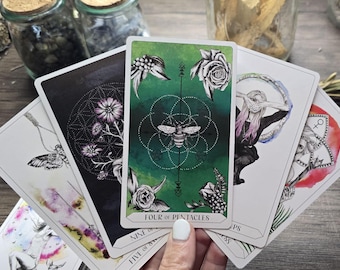 Puede incluir: Un despliegue de cartas de tarot con una carta verde con una abeja y el texto "Four of Pentacles", una carta negra con un diseño floral, una carta blanca con una polilla, una carta blanca con una mujer sosteniendo una luna creciente y una carta roja con una polilla.
