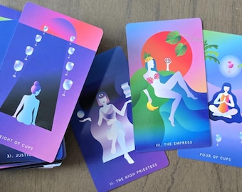 May include: A deck of tarot cards with vibrant illustrations. The cards depict figures, cups, and palm trees. The Eight of Cups, The Empress, The High Priestess, and Four of Cups are visible. The cards have a gradient colour scheme of purple, blue, and pink.