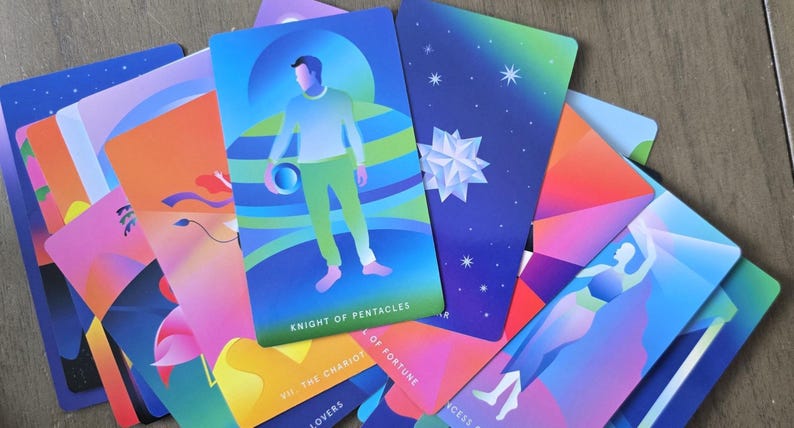 May include: A collection of colorful tarot cards with vibrant illustrations. The Knight of Pentacles card features a figure in green and blue. Other cards display celestial and geometric designs, with text including "The Chariot" and "Lovers".