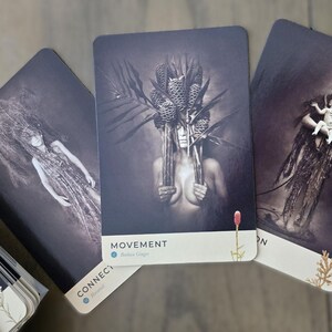 May include: Three tarot cards with black and white images of women with floral headpieces. The cards are titled "Connect", "Movement", and "Own".