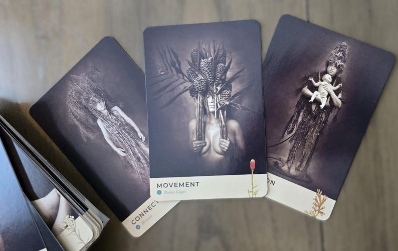 May include: Three tarot cards with black and white images of women with floral headpieces. The cards are titled "Connect", "Movement", and "Own".