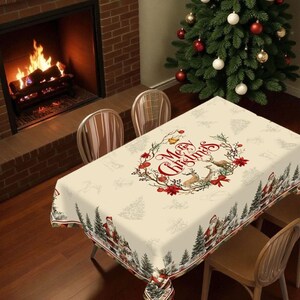 Peut inclure: Nappe de Noël crème avec une couronne ornée des mots "Merry Christmas", des cerfs et des poinsettias rouges. La bordure présente des images du Père Noël et de sapins de Noël. Un sapin de Noël décoré et une cheminée sont en arrière-plan.