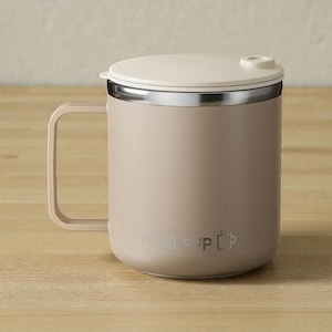May include: A beige insulated mug with a matching lid and handle. The mug has a silver rim and a small logo on the side. The lid has a small opening for drinking. The mug is designed for hot or cold beverages.