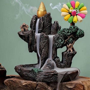 May include: A decorative incense burner shaped like a mountain with a waterfall feature. The dark brown resin structure includes a small house, a tree, and a gold-colored cone. A bundle of 60 colorful incense cones is included.