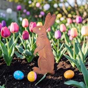 Peut inclure: Un lapin de Pâques en métal rouillé se dresse au milieu de tulipes colorées et d'œufs de Pâques décorés. Le lapin est de couleur marron rouille et présente un design simple. Les œufs sont peints avec divers motifs et couleurs.