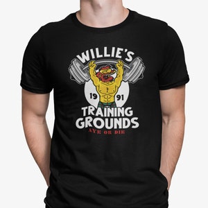 May include: Black t-shirt with a white graphic of a cartoon character lifting weights. The graphic includes the text "Willie's Training Grounds Aye or Die" and the years "1991".