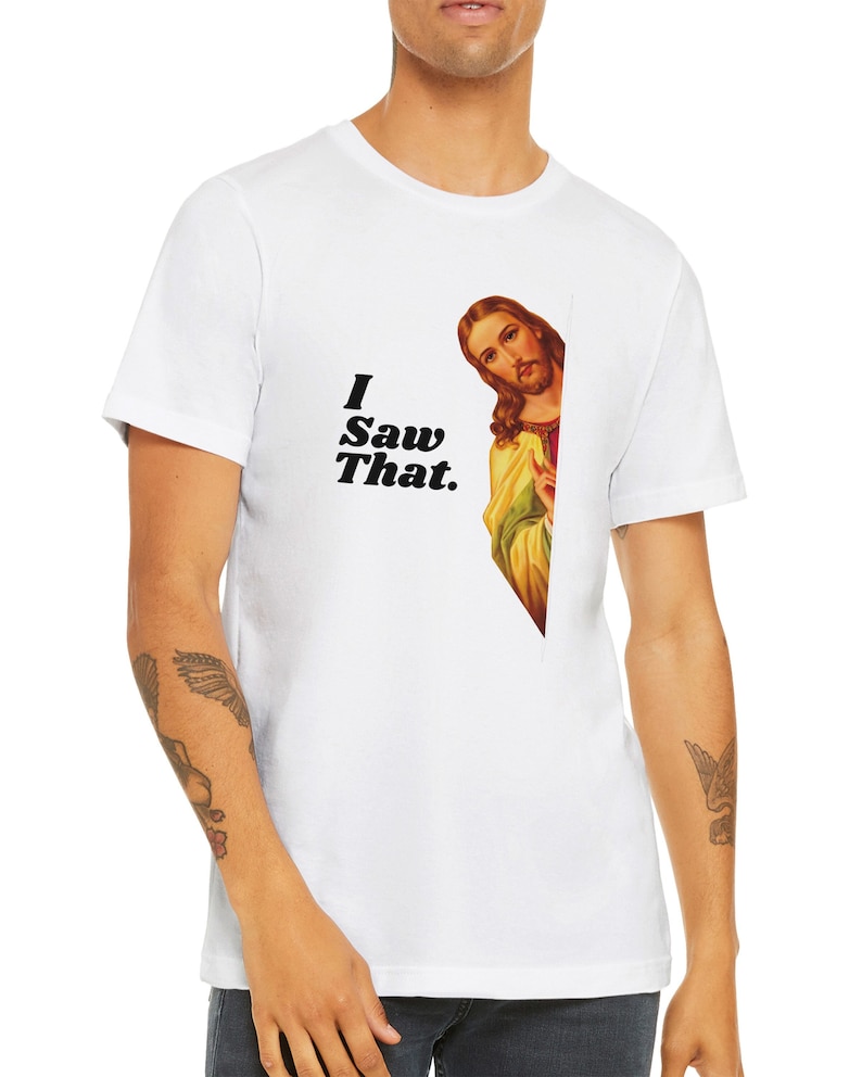 May include: White t-shirt with a graphic of Jesus peeking around a corner and the text "I Saw That."