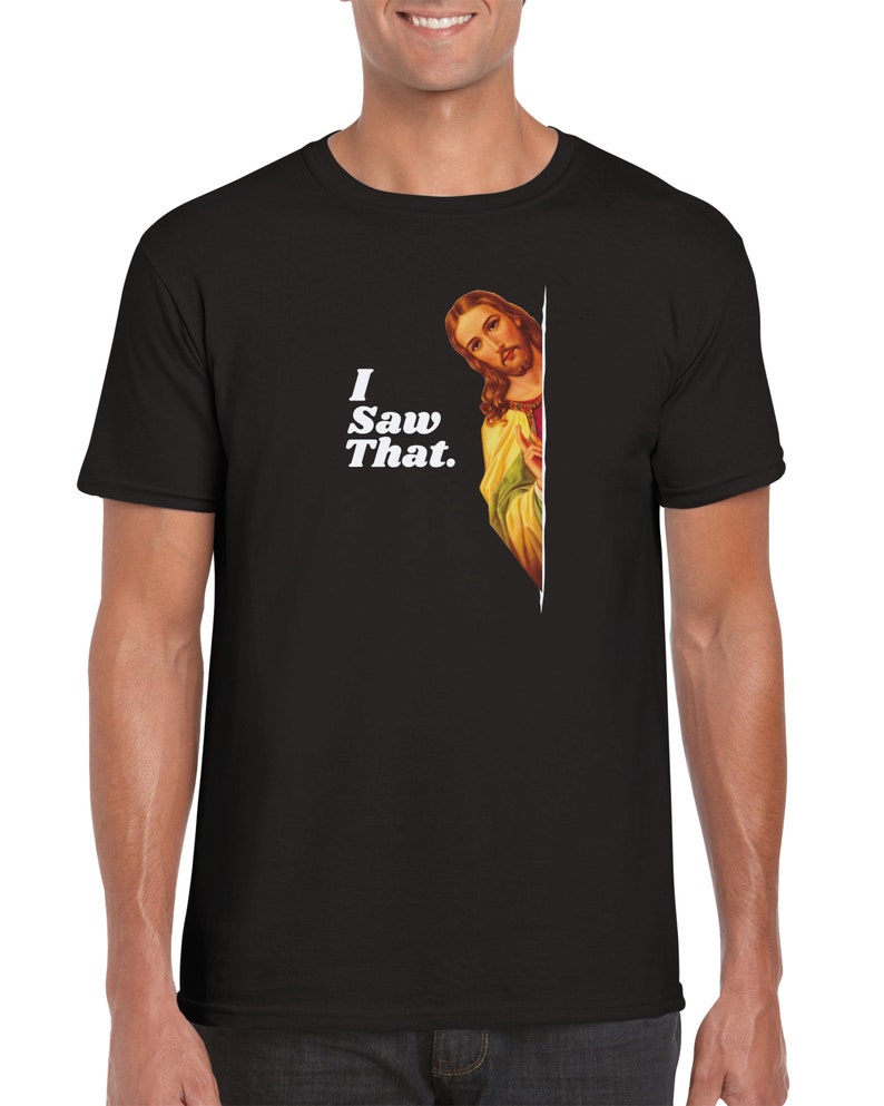 May include: A black t-shirt with a white graphic of Jesus peeking around a corner and the text "I Saw That."