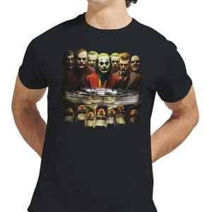 May include: Black t-shirt featuring a graphic of multiple Joker characters. The image includes various depictions of the Joker, with a central figure in a red suit and green hair. The design is a detailed illustration.