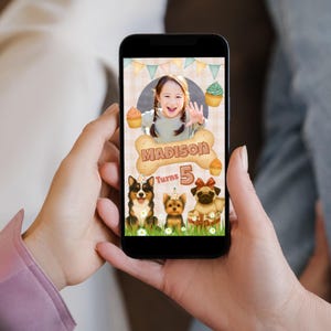 May include: A smartphone displays a birthday graphic featuring a girl waving, surrounded by cupcakes and three cartoon dogs. The text reads "Madison Turns 5" on a bone-shaped design, with a banner background.