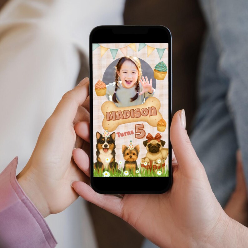 May include: A smartphone displays a birthday graphic featuring a girl waving, surrounded by cupcakes and three cartoon dogs. The text reads "Madison Turns 5" on a bone-shaped design, with a banner background.