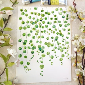 May include: Watercolor painting of a string of green leaves hanging down. The painting is on white paper with a white background. The painting is signed "Little Bug" in the bottom right corner.