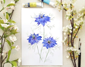 May include: A watercolour painting on white paper featuring three vibrant blue Nigella flowers with intricate, feathery green foliage. The artwork displays detailed petals in shades of deep and light blue, with delicate stems and leaves extending outwards.