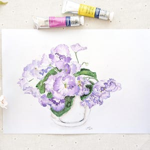 May include: A watercolor painting of a bouquet of purple African violets in a white vase. The painting is on a white background and has a simple, elegant style.