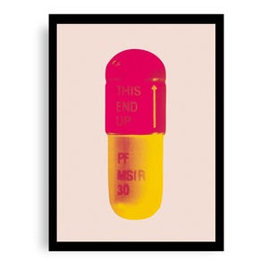 Op de afbeelding: Een roze en gele pilcapsule met de tekst "THIS END UP" en "PF NSIR 30" erop gedrukt.