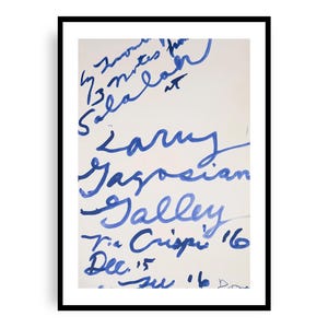 May include: A framed artwork featuring blue handwritten text on a white background. The text includes names, dates, and the words "Gallery" and "Crispi." The artwork is encased in a black frame.