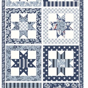 May include: A patchwork quilt featuring eight star-shaped blocks in shades of blue and white. The blocks showcase various patterns, including floral, gingham, stripes, and stars. The quilt has a decorative border with floral and dotted patterns.