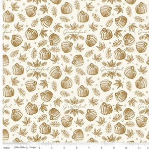 May include: A white fabric with a gold pattern of pumpkins, leaves, and the word "Grateful".