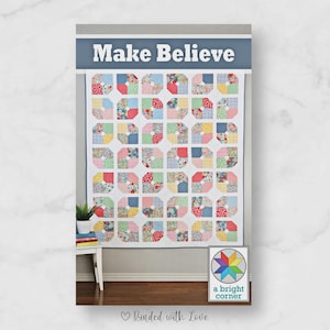 May include: A colorful quilt with the words "Make Believe" at the top. The quilt features a repeating pattern of octagonal blocks in various floral and patterned fabrics. A small framed image with a starburst design is in the lower right corner.
