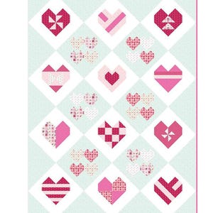 May include: A quilt pattern with a light blue background and pink and red hearts. The hearts are arranged in a diamond pattern and each heart has a different design.
