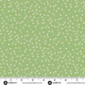 May include: A light green fabric with a repeating pattern of small, four-pointed star shapes in white and light blue. The stars are scattered across the fabric, creating a delicate, textured appearance. The fabric is measured with a ruler in inches.