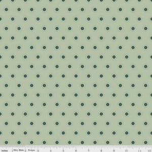 May include: A light green fabric with a repeating pattern of dark green polka dots. The dots are evenly spaced across the surface. The fabric is measured in inches.
