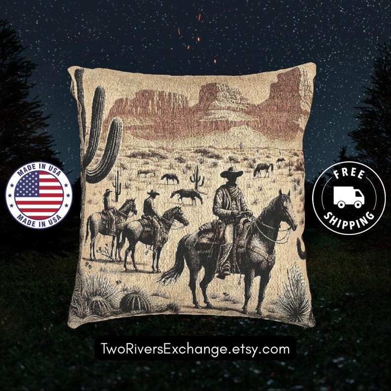 May include: Beige tapestry pillow featuring a Western scene with cowboys on horseback, cacti, and a desert landscape. The pillow has a vintage aesthetic, with a detailed illustration in shades of brown and black. The pillow is square-shaped.