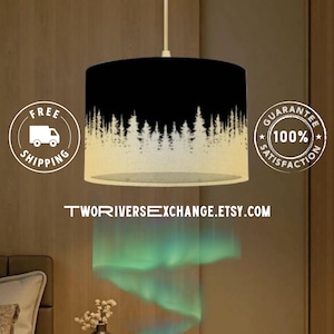 May include: A black and white pendant lamp with a forest silhouette design. The lamp has a cylindrical shade with a black top and a white forest scene at the bottom. The text "TwoRiversExchange.Etsy.com" is visible.