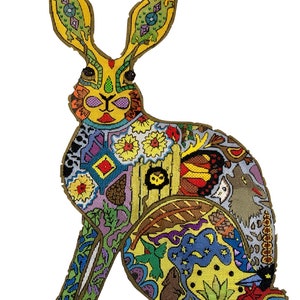 May include: A colourful, patterned rabbit with a yellow base and intricate details. The rabbit is sitting with its ears perked up and its tail tucked behind it. The design features a variety of colours and patterns, including flowers, butterflies, and geometric shapes.