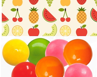 May include: A collection of colorful, glossy gumballs in shades of yellow, green, pink, orange, and red. The gumballs are arranged in a cluster against a backdrop of a repeating fruit pattern, including strawberries, cherries, and pineapples.