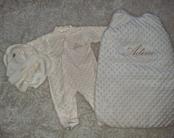 Personalized baby box containing pajamas sleeping bag hat mittens bodysuit and bib