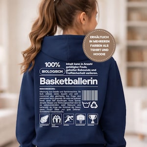 Può includere: Una felpa con cappuccio blu navy con testo e grafica bianchi. Il testo include "100% BIOLOGISCH" e "Basketballerin". Ulteriore testo descrive le azioni di basket. Una grafica circolare dice "DISPONIBILE IN PIÙ COLORI COME T-SHIRT E FELPA CON CAPPUCCIO."