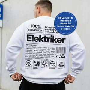 Könnte beinhalten: Ein weißes Langarm-Sweatshirt mit schwarzem Text und Grafiken auf der Rückseite. Das Design enthält das Wort Elektriker, einen Barcode und verschiedene Symbole mit deutschem Text. Ein blaues rundes Abzeichen weist auf weitere Farben hin.