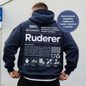 Puede incluir: Sudadera con capucha azul marino con texto y gráficos blancos. La parte posterior de la sudadera con capucha presenta la palabra "Ruderer" y otro texto, incluido "100% BIOLOGISCH". Un gráfico circular dice "DISPONIBLE EN MÁS COLORES COMO CAMISETA, SUÉTER Y SUDADERA CON CAPUCHA".