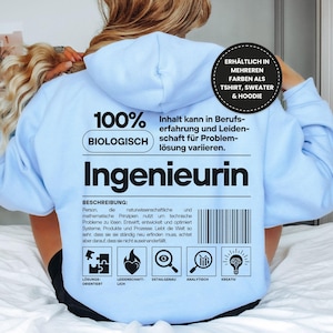 Puede incluir: Sudadera con capucha azul claro con la palabra "Ingenieurin" en letras grandes. La parte trasera presenta texto en alemán e iconos relacionados con la resolución de problemas y la creatividad. Disponible como camiseta, suéter y sudadera con capucha.