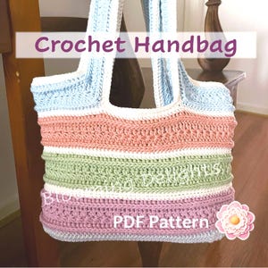 May include: A crocheted handbag with a striped design in pastel colors, including light blue, pink, green, and purple. The bag has a wide, flat base and two long straps. The text "PDF Pattern" is visible on the bag.