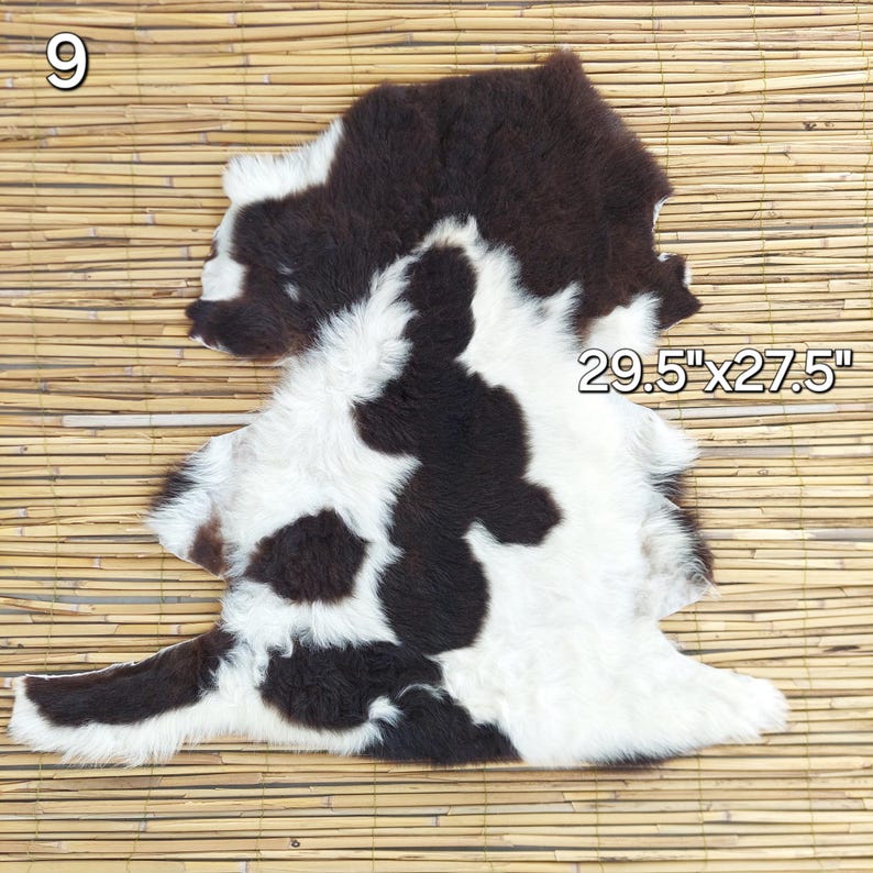 May include: A cowhide rug with a unique pattern of black and white patches. The rug measures 29.5 inches by 27.5 inches. The natural fur has a soft texture. The rug is displayed on a bamboo mat.