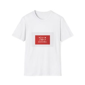 Könnte beinhalten: Weißes T-Shirt mit einem rechteckigen roten Grafik. Die Grafik zeigt die Worte "Love, Coffee & Good Vibes" in weißer Schrift, mit kleinen Herzsymbolen. Das T-Shirt hat einen Rundhalsausschnitt und kurze Ärmel.