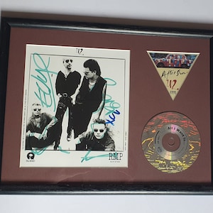 Pode incluir: Um display emoldurado com uma capa de álbum U2 assinada, um passe de turnê 'After Show' do U2 e um CD single da música 'All I Want Is You'.