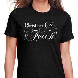 Peut inclure: T-shirt noir à col rond avec le texte blanc "Christmas Is So Fetch" et des étoiles. Le t-shirt est fait d'une matière douce et convient aux tenues décontractées. Un t-shirt de vacances amusant et festif.