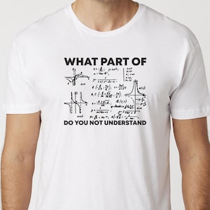 May include: White t-shirt featuring the text "WHAT PART OF DO YOU NOT UNDERSTAND" in black, accompanied by mathematical equations and graphs. The shirt has a crew neck.