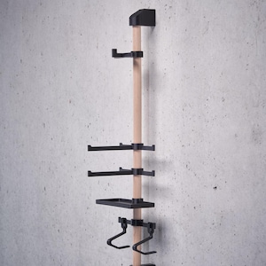 May include: A wall-mounted wooden rack with black metal shelves and hooks. The rack has two shelves, two hooks, and a small tray.