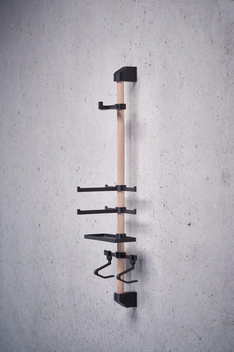 May include: A wall-mounted wooden rack with black metal shelves and hooks. The rack has two shelves, two hooks, and a small tray.