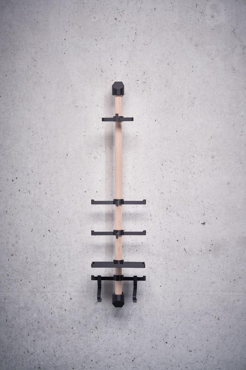 May include: A wooden wall-mounted coat rack with black metal hooks and a shelf. The rack has four hooks and one shelf.
