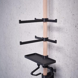 May include: A wooden pole with black metal shelves and hooks. The shelves are adjustable and can be moved up or down the pole. The hooks are also adjustable and can be moved to different positions on the shelves.
