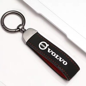 May include: Black leather keyring with a silver metal ring and a white Volvo logo with a red stitched border.