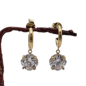 Piccoli orecchini a cerchio in argento sterling 925, placcati in oro 24k, con zirconi pendenti a forma di cuscino. Orecchini creati da Maison Noora.
