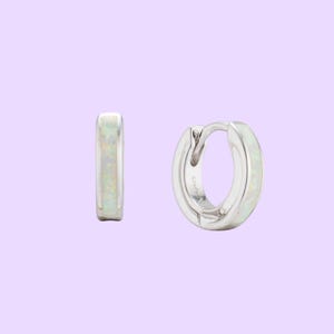 Iridescent white opal inlay huggie hoops. Rhodium-plated dainty silver earrings developed by Maison Noora. Ready-to-gift opal jewelry