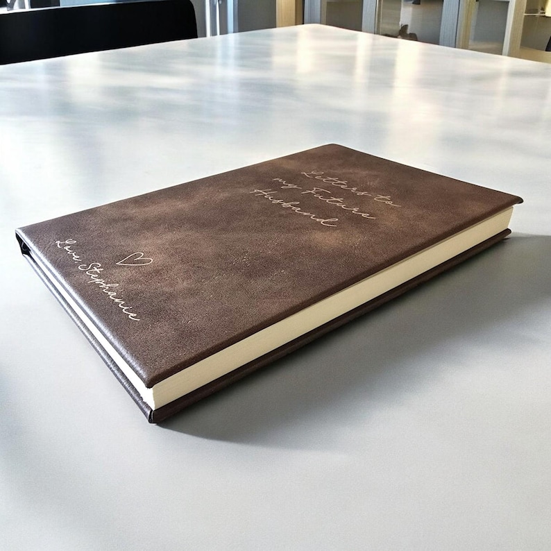 May include: A brown leather-bound journal with the text "Letters to my future husband" and "Love, Stephanie" embossed on the cover.