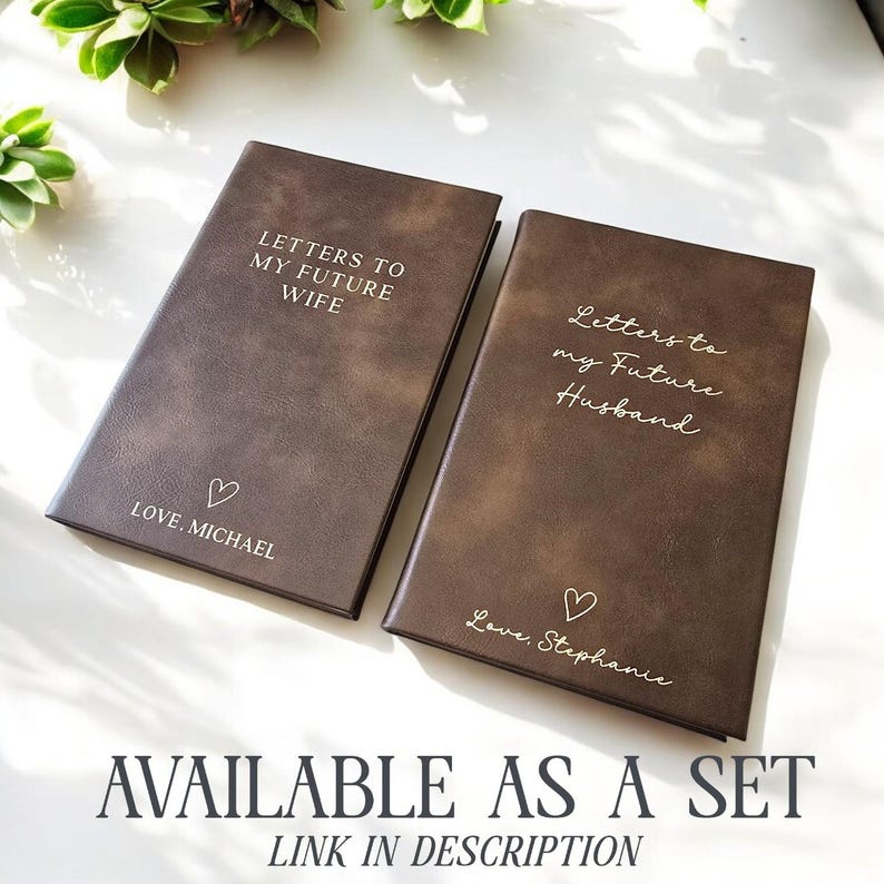 May include: Two brown leather journals with gold lettering. The journal on the left says "Letters to my Future Wife" and "Love, Michael". The journal on the right says "Letters to my Future Husband" and "Love, Stephanie".